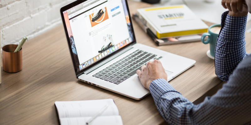 Man browsing through a website on his desk. 