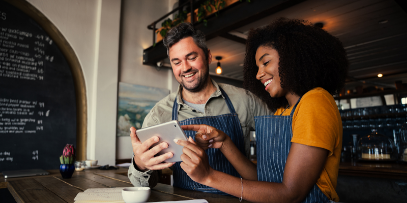 coffee shop owners looking at an ipad on the counter.
