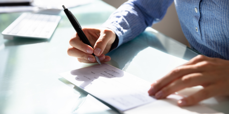 Person signing a check. 
