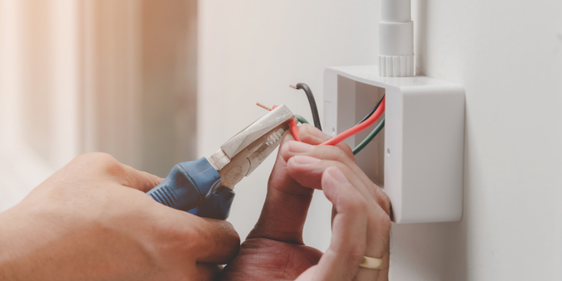 Electrician using pliers on a cable. 