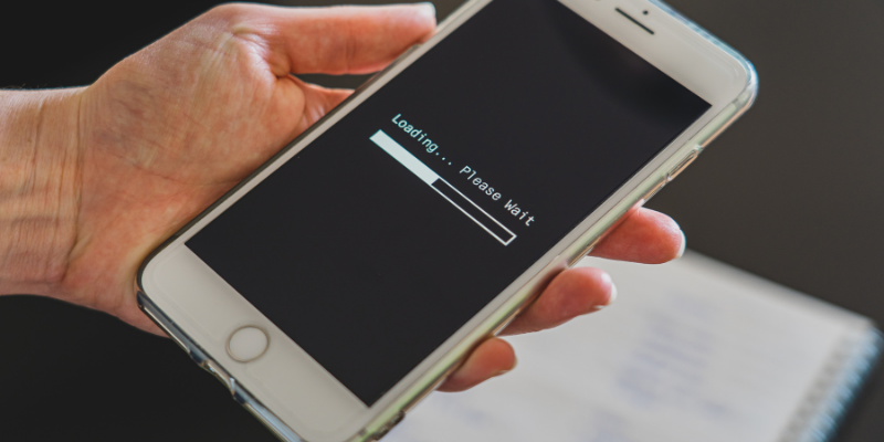 Person holding a phone showing a loading page. 