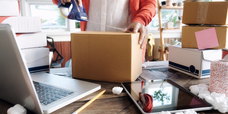 Business owner packaging products on his desk. 