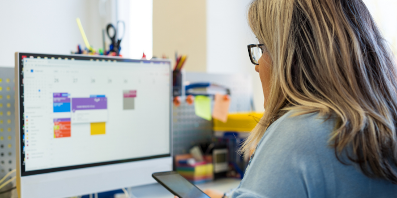 Business owner looking at a desktop with her calendar pulled up on the screen.