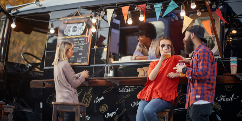Group of people drinking near a mobile bar.