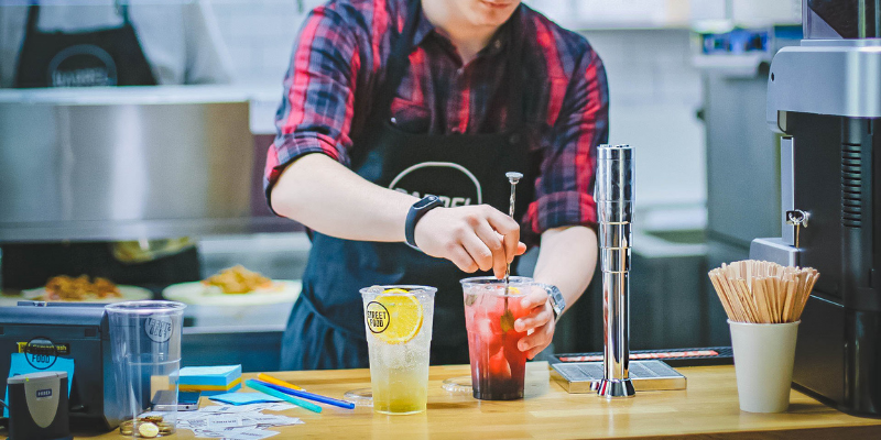 Restaurant employee preparing a beverage.