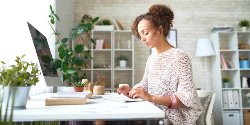 Business owner sending an appointment reminder through email on her desktop computer.