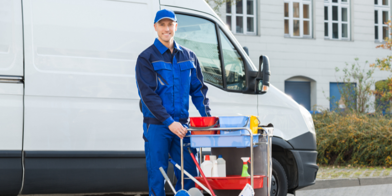 Man loading cleaning supplies to a company vehicle.