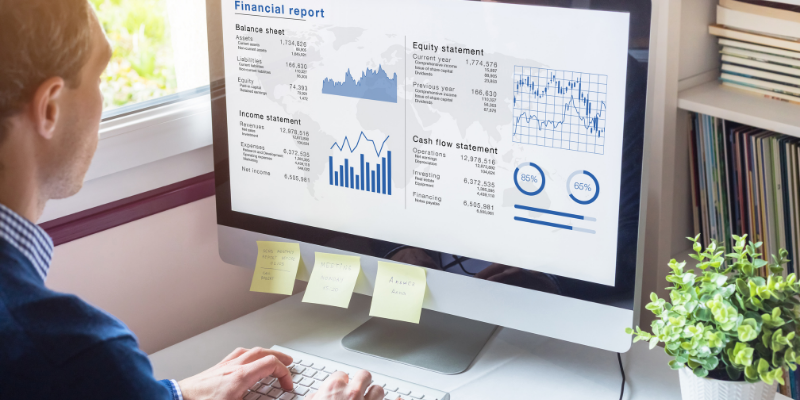 Business owner looking at a financial report on his computer.