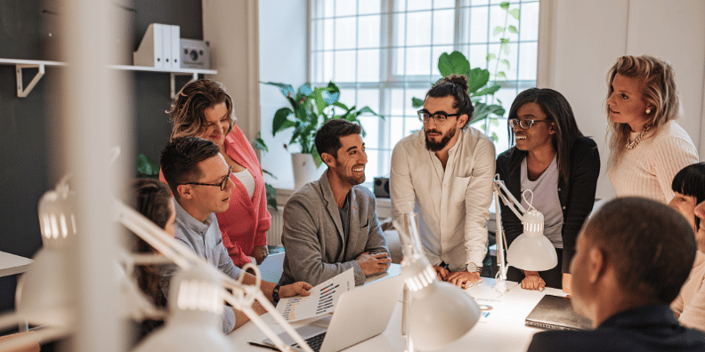 Group of people in an office looking at graphs.