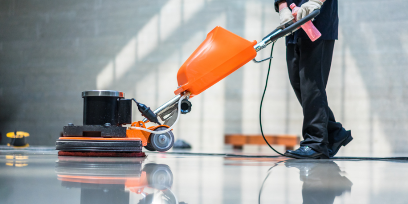 Man using a floor scrubber in an office.