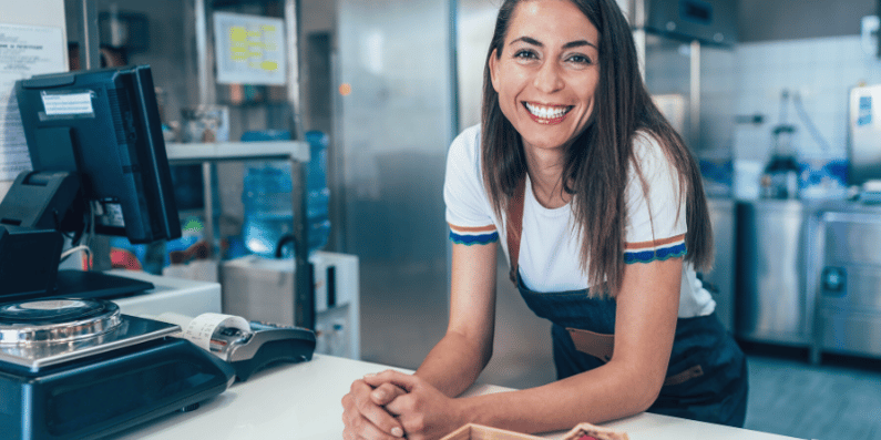 Business owner standing behind her cash register.
