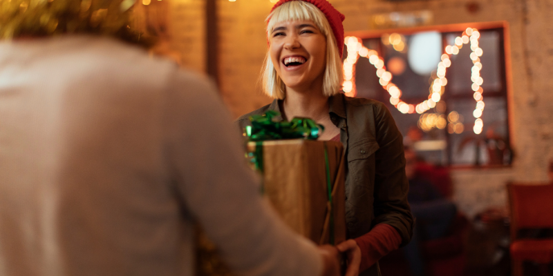 Customer receiving a Christmas gift from business owner.