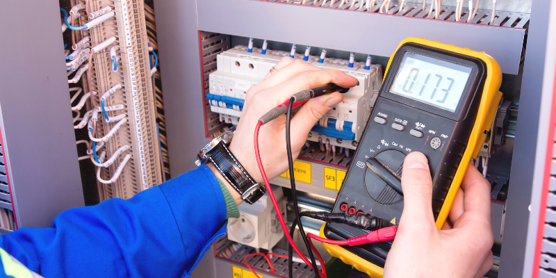 Electrical technician using a voltage tester.