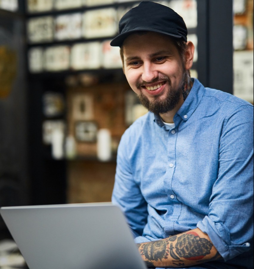 happy-tattooist-with-laptop-working-in-the-net-SBI-324036251-1