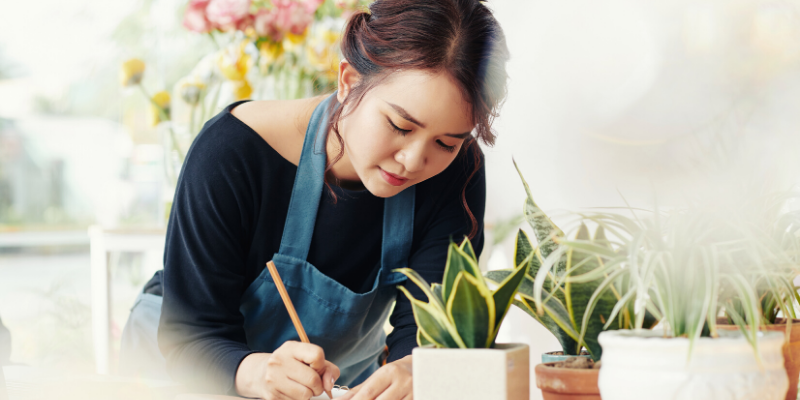 woman in an apron writing down notes.