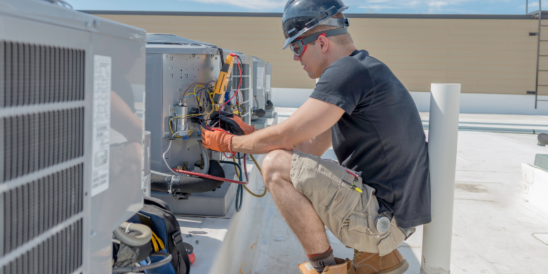 HVAC technician working on a commercial AC unit.
