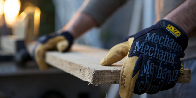 Person wearing the Mechanix Wear's Original Work Glove while cutting wood.