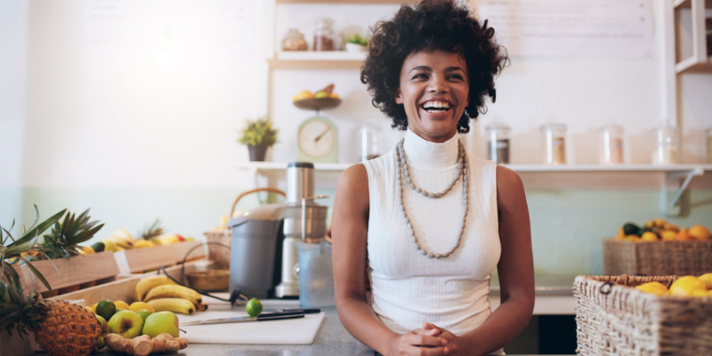 Black woman business owner standing in front of her counter. 
