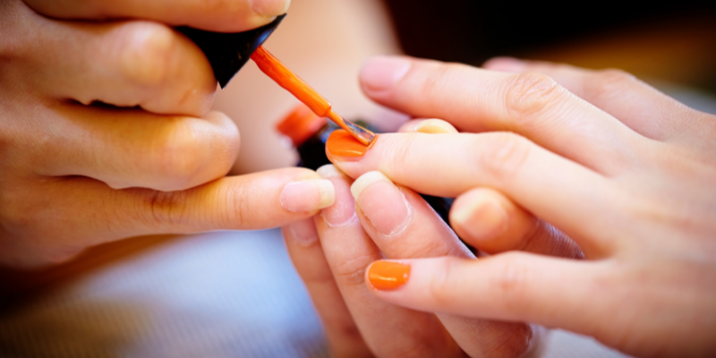 Nail artist painting a client's nails.