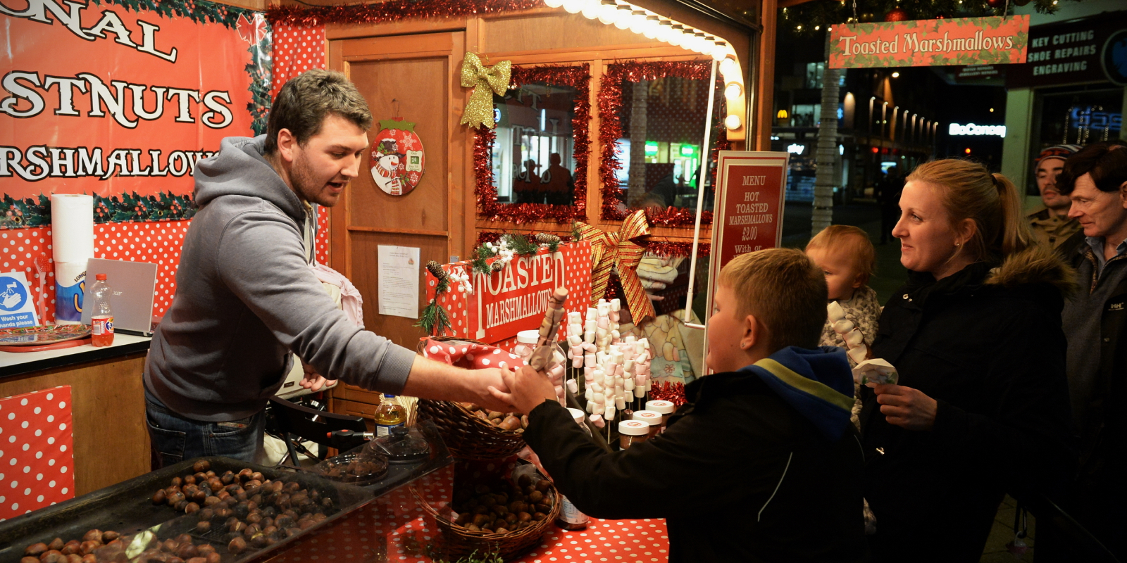 man selling candy to a family at the store