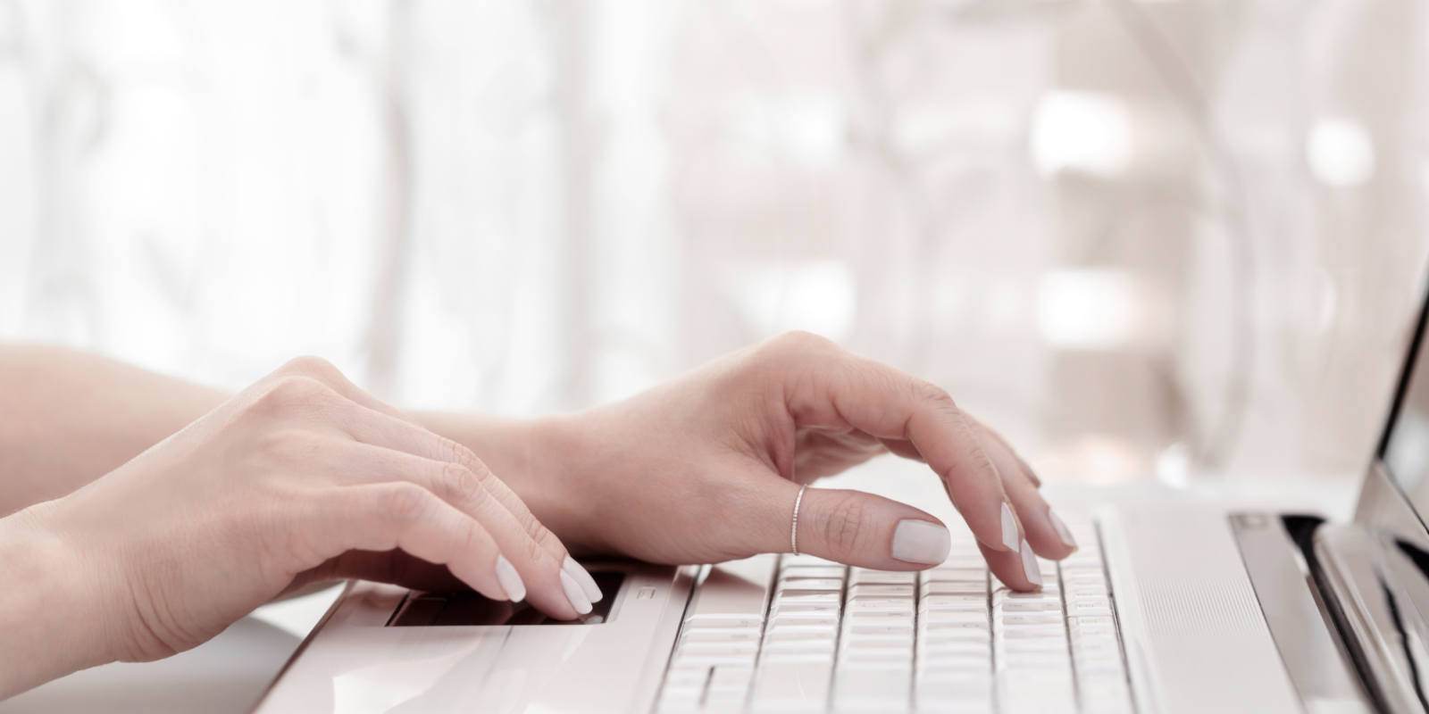 woman's hands typing on a laptop