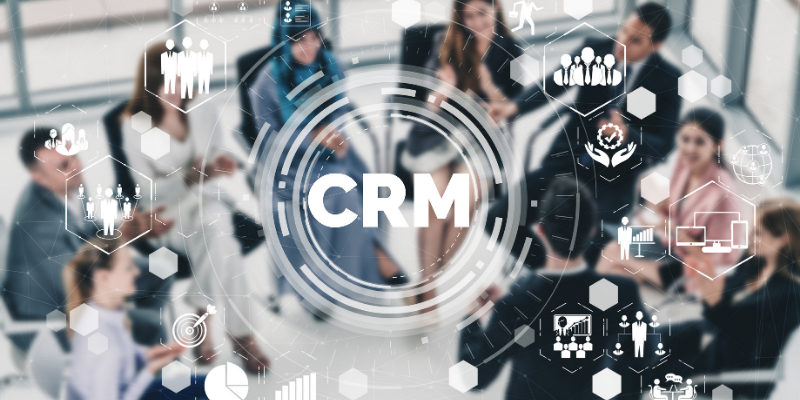 "CRM" displayed in the foreground of an image of a group of people